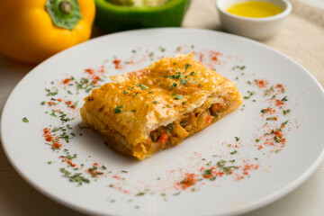 Puff pastry empanada filled with vegetables and squid.