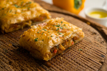 Puff pastry empanada filled with vegetables and squid.