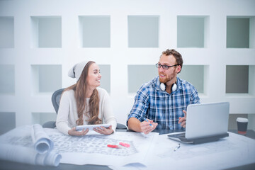 Young man and woman discussing project in design office