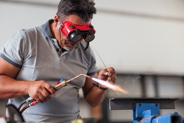 Mechanic welding in car workshop