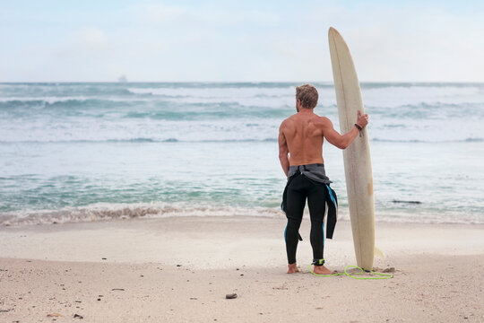 Man on the beach with surfboard