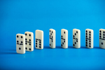 Dominoes standing on a blue background.