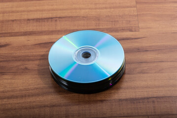 Many CDs isolated on wooden background.