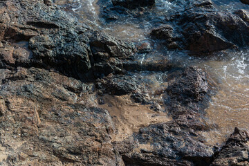 Dark rocks on a beach.