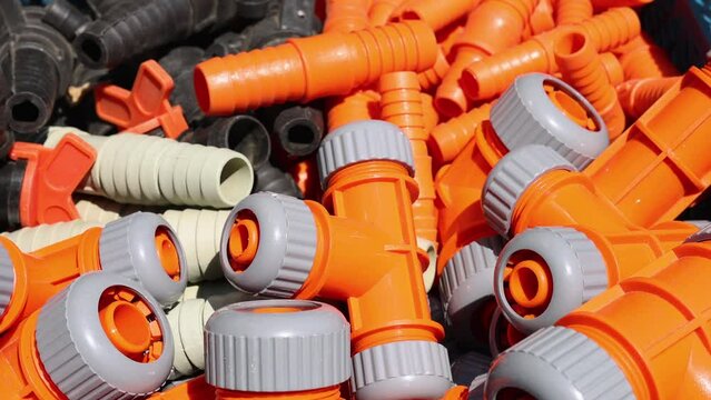 Colorful plastic hose fittings and adapters. Many large pile,adapters, for garden hose for irrigation.