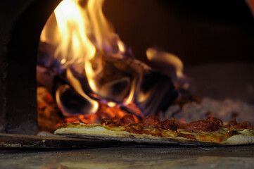 Close-up of delicious pizza being cooked in a burning oven