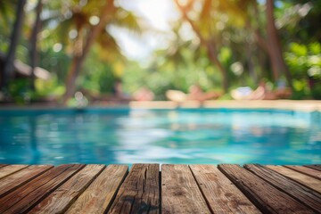 Fototapeta premium Empty Wooden table top with a tropical background of a swimming pool and palm trees in the sunlight. summer and vacation concept, copy space for text