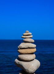 Pyramid of stones against the background of the sea. Calm. Harmony.