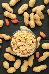 Roasted peanuts on bowl on black wooden background