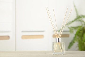 Aroma sticks in glass bottle. Aroma diffuser on table in room