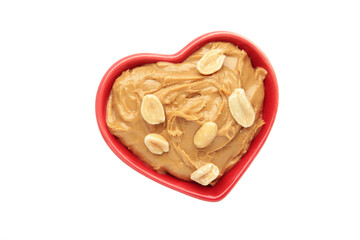 Heart shaped bowl with peanut butter and peanuts isolated on white background. Creamy peanut pasta in small bowl.