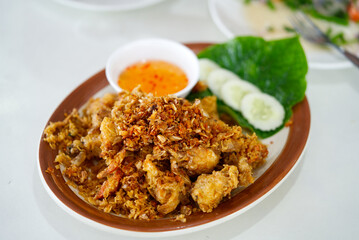 Thai food delicious menu, deep fried soft shell crab. Deep fried soft shell crabs with sweet sauce and silced cucumbers and green leaf vegetables on white table.