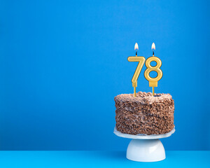Birthday celebration with candle 78 - Chocolate cake on blue background