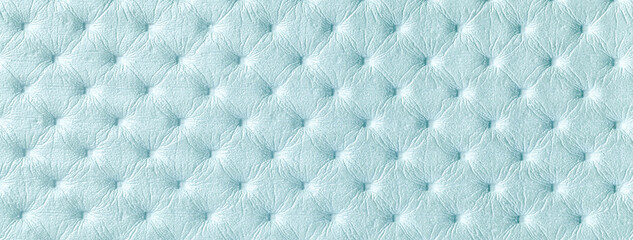Texture of light blue leather background with capitone pattern, macro. Sky pastel textile of retro Chesterfield style.