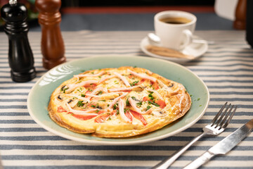 Healthy breakfast. Omelette of beaten eggs with tomatoes and bacon served on a plate.