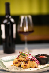 Dinner at the restaurant. Chicken shashlik served on a plate with lavash and red wine