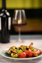 Mixed grilled vegetables served with red wine in a restaurant. Luxury restaurant dinner concept