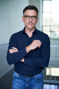 Portrait von einem mittel alten Mann mit Brille und Dreitagebart im Dunkelblauen Hemd
