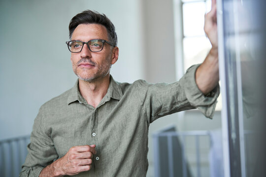Portrait von einem mittel alten Mann mit Brille und Dreitagebart im wei&szlig;en Hemd
