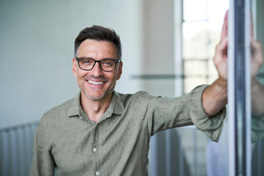Portrait von einem mittel alten Mann mit Brille und Dreitagebart im wei&szlig;en Hemd