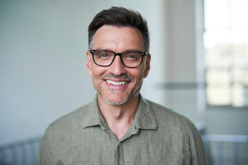 Portrait von einem mittel alten Mann mit Brille und Dreitagebart im weißen Hemd