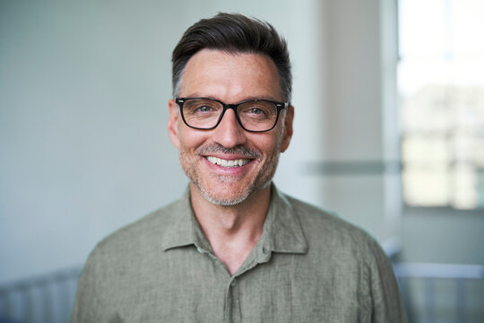 Portrait von einem mittel alten Mann mit Brille und Dreitagebart im wei&szlig;en Hemd