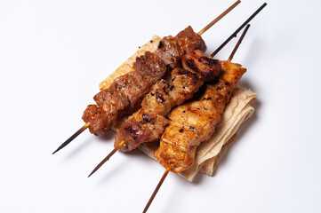 close-up view of delicious kebabs on skewers on white background