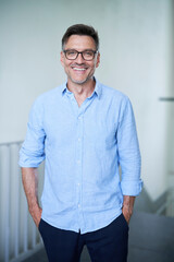 Portrait von einem mittel alten Mann mit Brille und Dreitagebart im blauen Hemd 