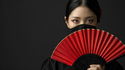 A woman holding an asian red folding fan