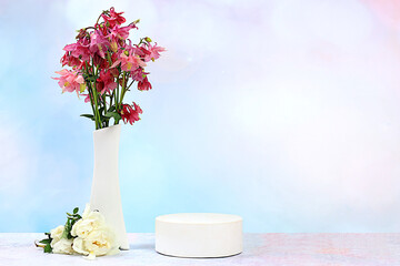 Beautiful spring blooming aquilegias and roses in a vase on a sunny background, banner. Abstract floral arrangement with empty podium for product display, template for display, 