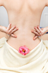 Back of a girl with a towel and a flower, close up, spa