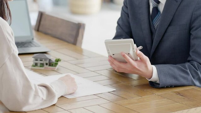 不動産の見積もりを計算するビジネスマンの手元