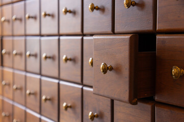 A wooden chest with many drawers and a drawer that is open