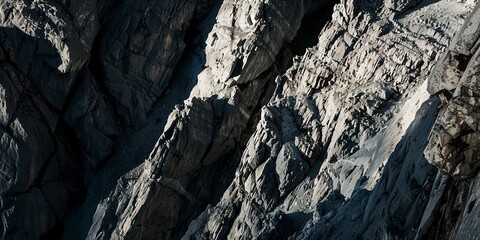 Panoramic view of mountain cliffs, close-up on rugged textures and shadows, intense midday lighting. 