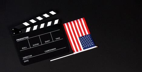 Clapper board and USA flag on black background