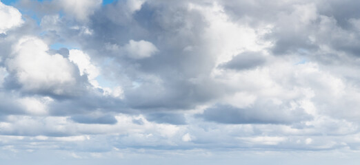 White cumulus clouds are in blue sky on a summer day, panorama
