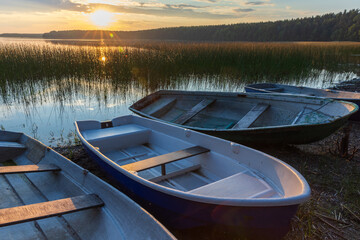 Obraz premium Small rowboats lay on the lake coast in the evening