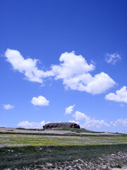 Obraz premium Landscape with blue sky and clouds. field and rocky hill