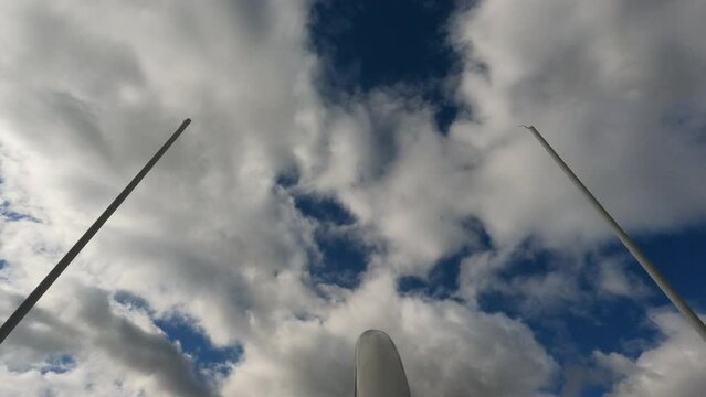 American Football Field Goal Posts against a cloudy blue sky. Upright metal posts form the goal through which a kicker kicks a football for extra point. 