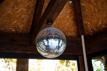 The disco ball adds a touch of glamour, sparkling in the welllit room. The atmosphere is vibrant, energetic, and full of excitement, creating a dynamic and lively space