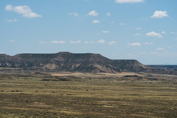 Expansive view of the rugged and scenic desert landscape in Las Bardenas Reales, Spain, showcasing the unique geological formations under a clear blue sky.