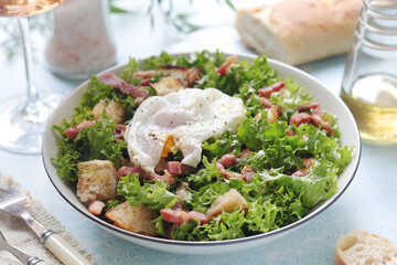A bowl with salad lyonnaise served for lunch	