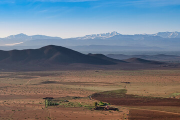 A beautiful view of the majestic Atlas mountains, from the Agafay Desert, on the outskirts of Marrakech, Morocco.  There is snow on the mountains.