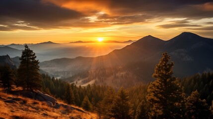 Obraz premium Breathtaking sunrise over a mountain range, casting golden light across a vast forest and distant peaks, creating a serene and majestic landscape.