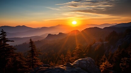 Breathtaking sunset over a serene mountain landscape with dense forests, casting a warm, golden hue across the horizon.