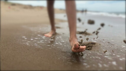 Child boy feet walking at the beach closeup