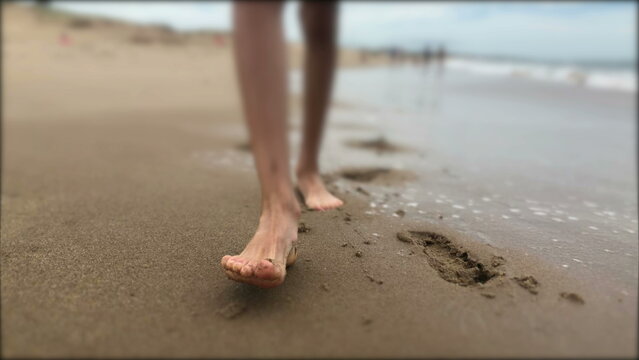 Child boy feet walking at the beach closeup
