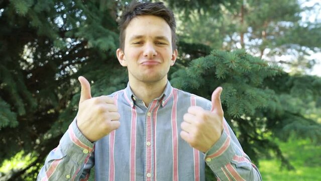 Man Giving Thumbs Up in Front of Tree