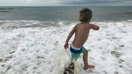 Baby boy toddler at the beach playing