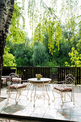 The patio is furnished with a table and chairs, nestled among trees, providing a serene space for outdoor activities and socializing, perfect for gatherings and leisurely pursuits